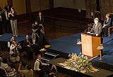 Harry Jenkins addressing an audience in the Great Hall of Parliament House, with various photographers and others in the foreground.