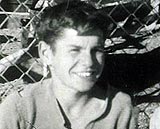 Mike O'Donoghue seated in front of a fence